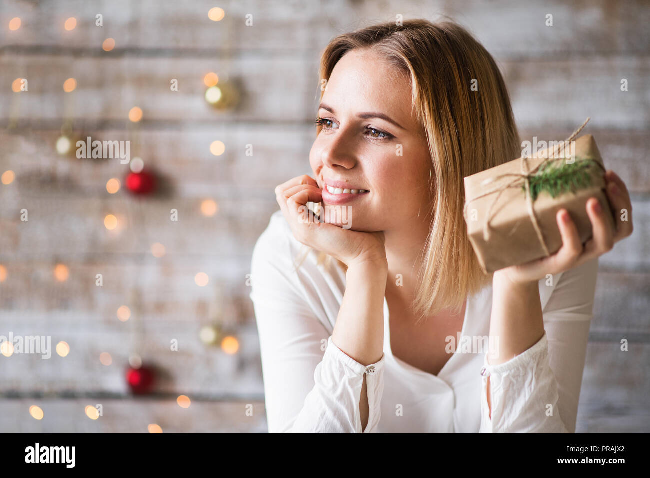 A young woman holding wrapped Christmas present Stock Photo Alamy