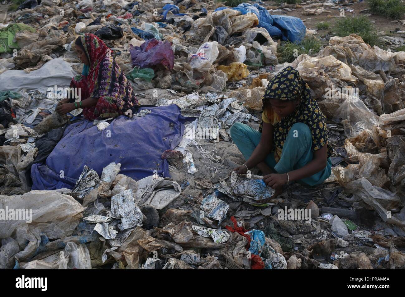 Dhaka, Bangladesh. 30th Sep, 2018. Women workers separate plastic bags on a wasteland in the outcast of Dhaka. A recent report by World Bank say, the country loses about $6.5 billion due to pollution and environmental degradation in urban arears in every year. Credit: MD Mehedi Hasan/ZUMA Wire/Alamy Live News Stock Photo