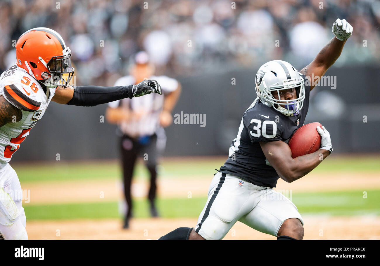 Oakland, California, USA. 30th Sep, 2018. Oakland Raiders running back Jalen Richard (30) fends off Cleveland Browns outside linebacker Christian Kirksey (58), during a NFL game between the Cleveland Browns and the Oakland Raiders at the Oakland Coliseum in Oakland, California. Valerie Shoaps/CSM/Alamy Live News Stock Photo