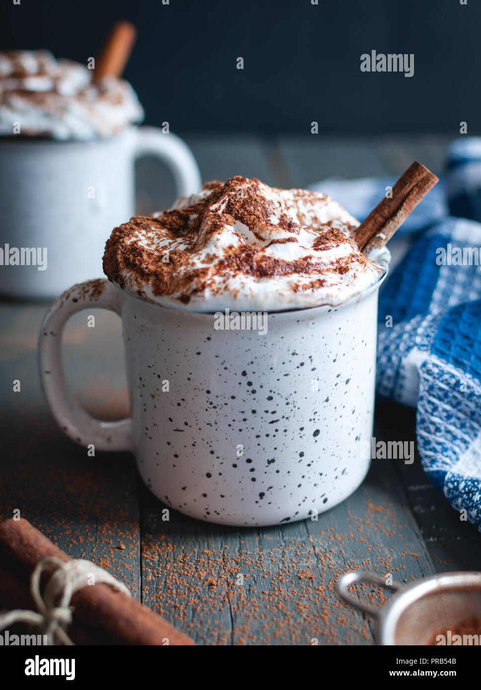 Hot cocoa with whipped cream and cinnamon stick on dark background Stock Photo