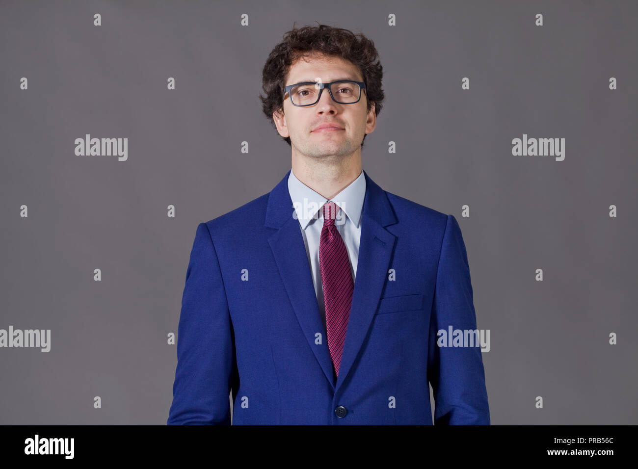 Young man wearing in blue suit and glasses smiling Stock Photo - Alamy