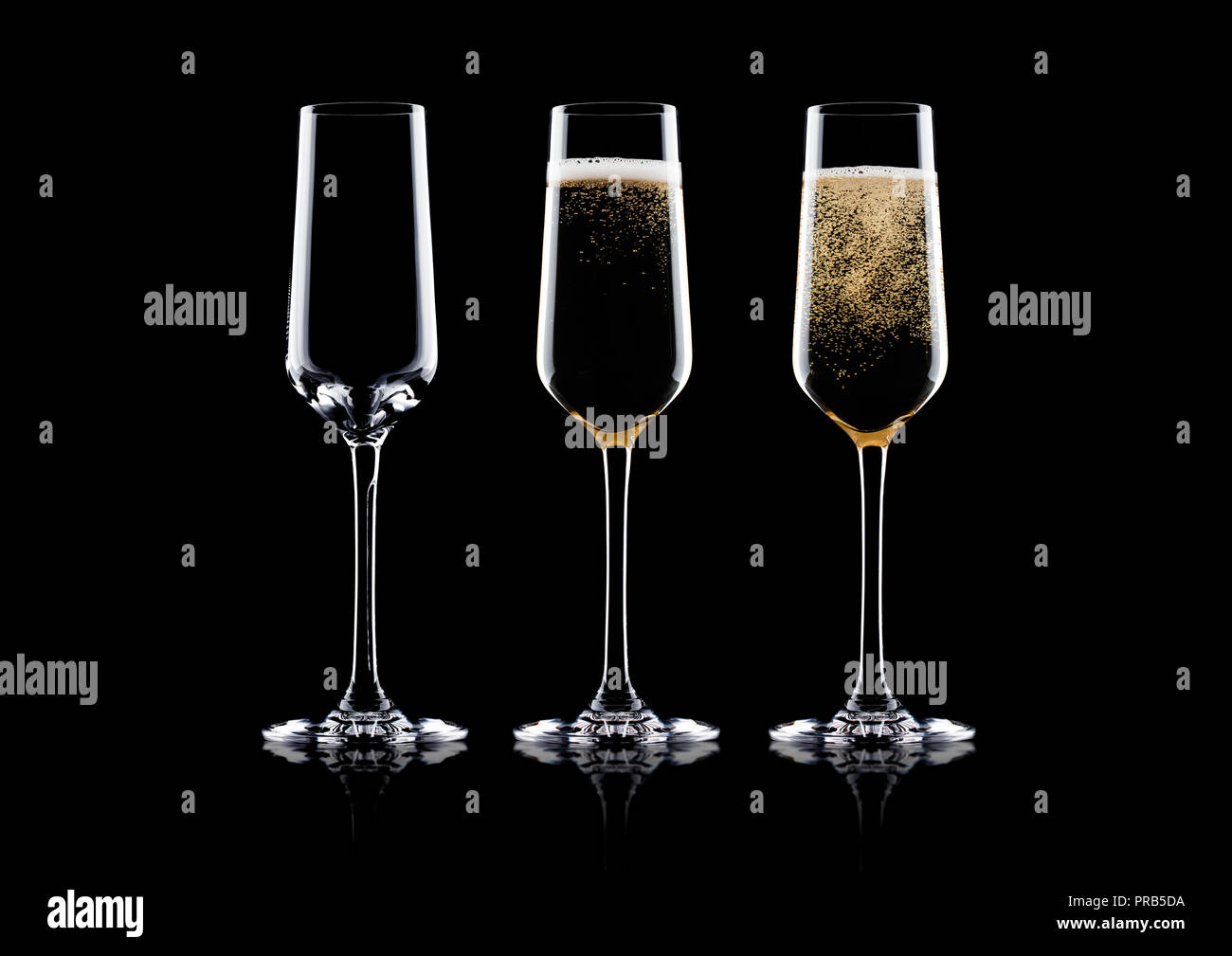 Elegant glasses of yellow champagne with bubbles on black background