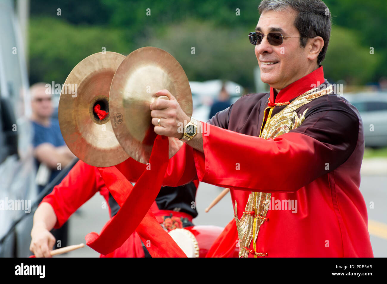 A Chinese Waist Drum Team, colorfully clad in traditional costume,  performs at a local festival. Stock Photo