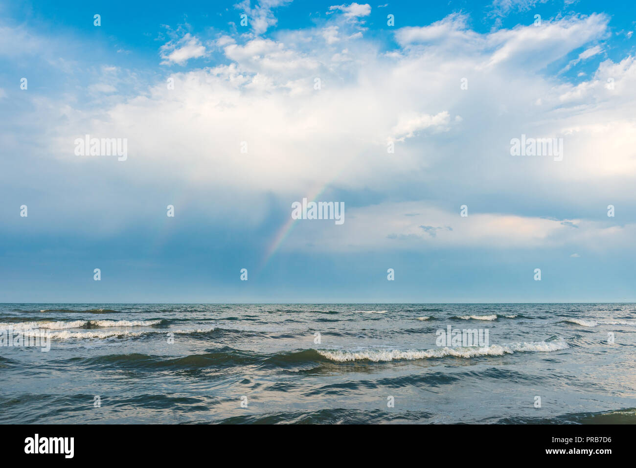 Rainbow over the sea after rain Stock Photo - Alamy