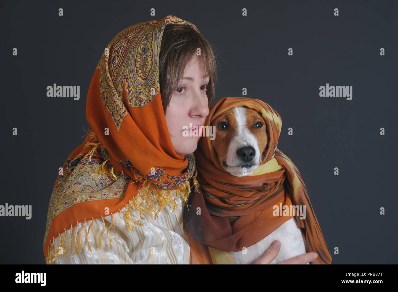 Nice portrait of beautiful woman with lovely basenji dog both wearing headscarfs Stock Photo