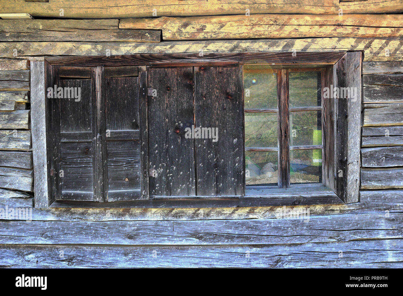 window with shutters on old wooden log house Stock Photo