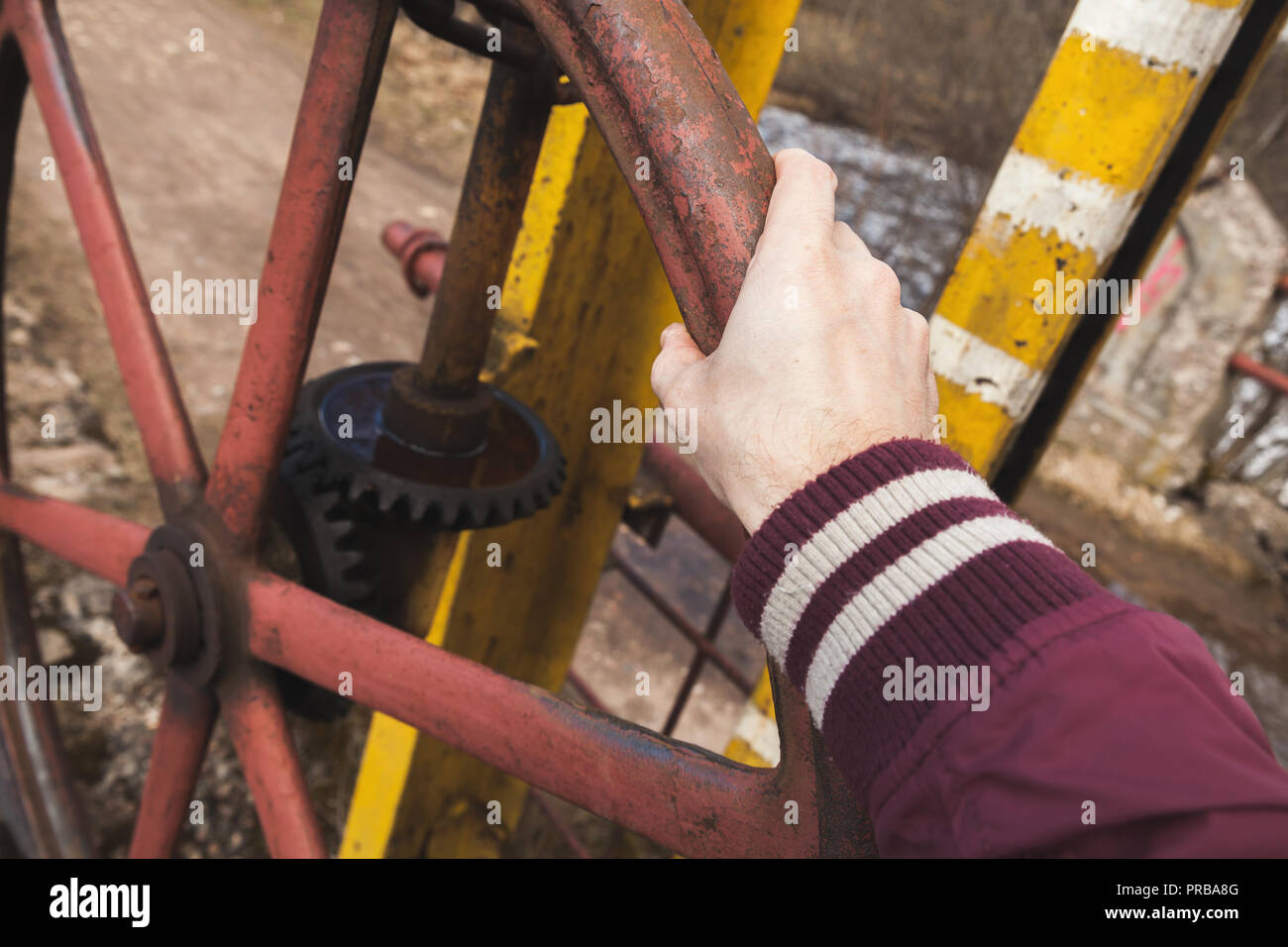 Male hand on industrial grungy handwheel, close-up photo Stock Photo