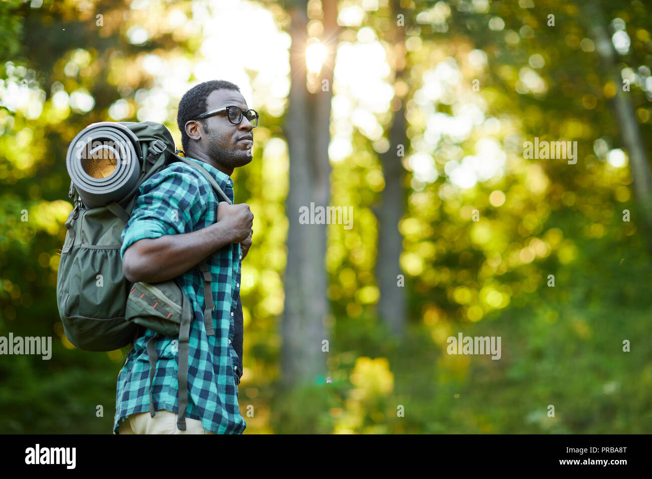 African-american guy carrying backpack on his back while moving in the ...