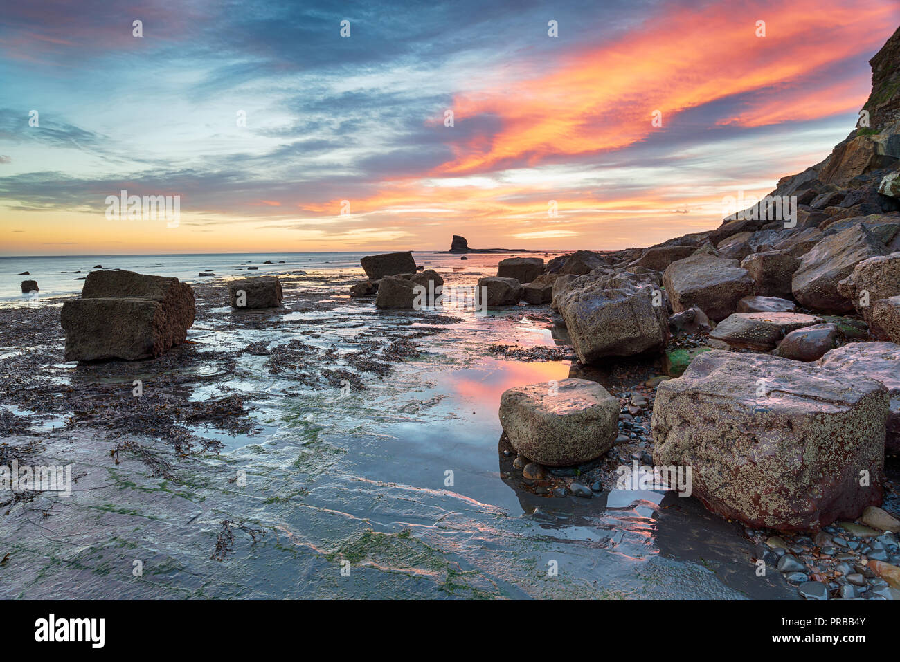 Stunning sunrise on the beach at Saltwick Bay on the North Yorkshire coast btween Whitby and Robin Hoods Bay Stock Photo