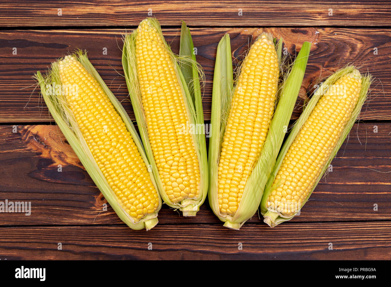 Corn cobs on wooden table. Stock Photo