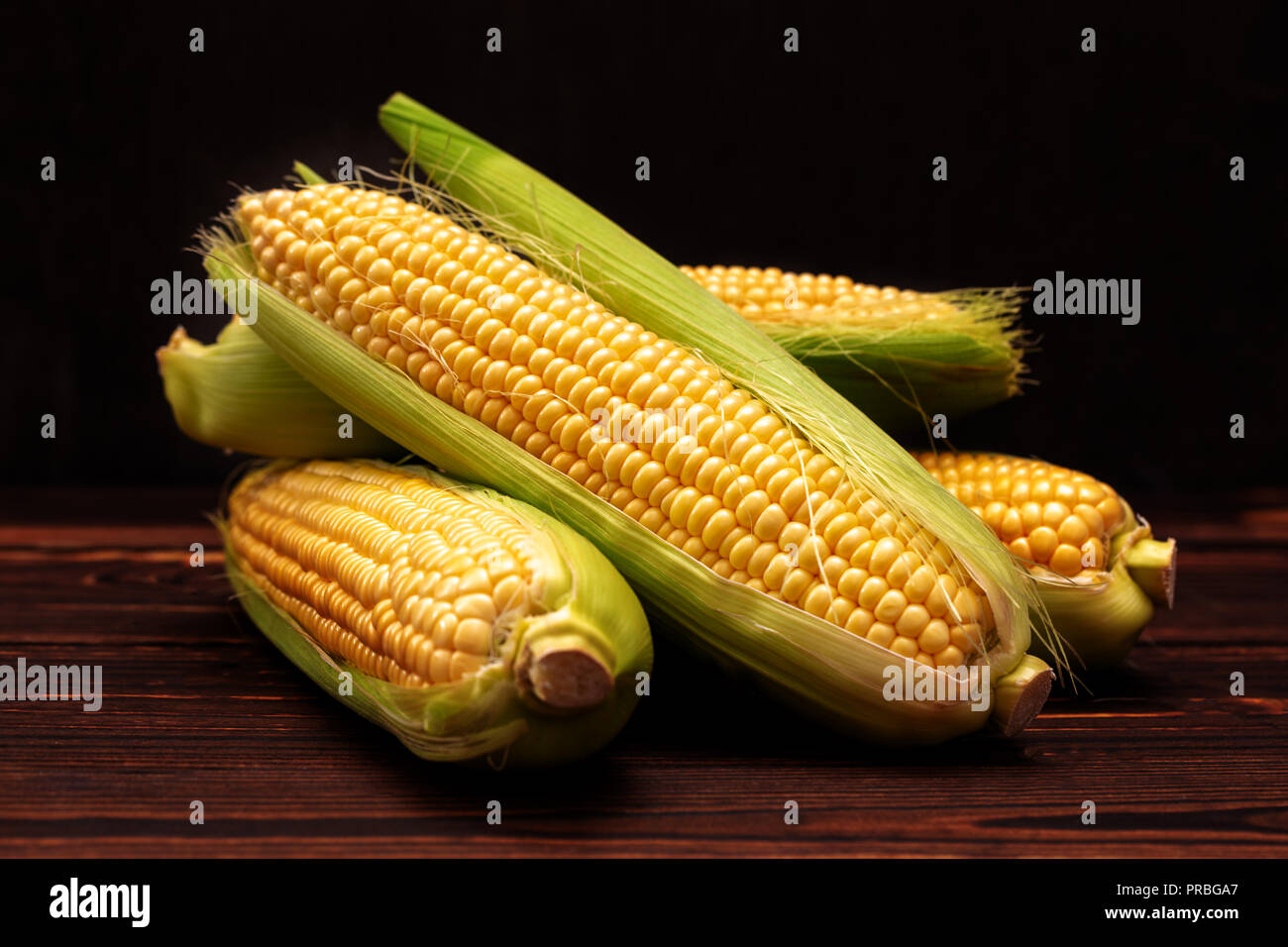 Corn cobs on wooden table. Stock Photo