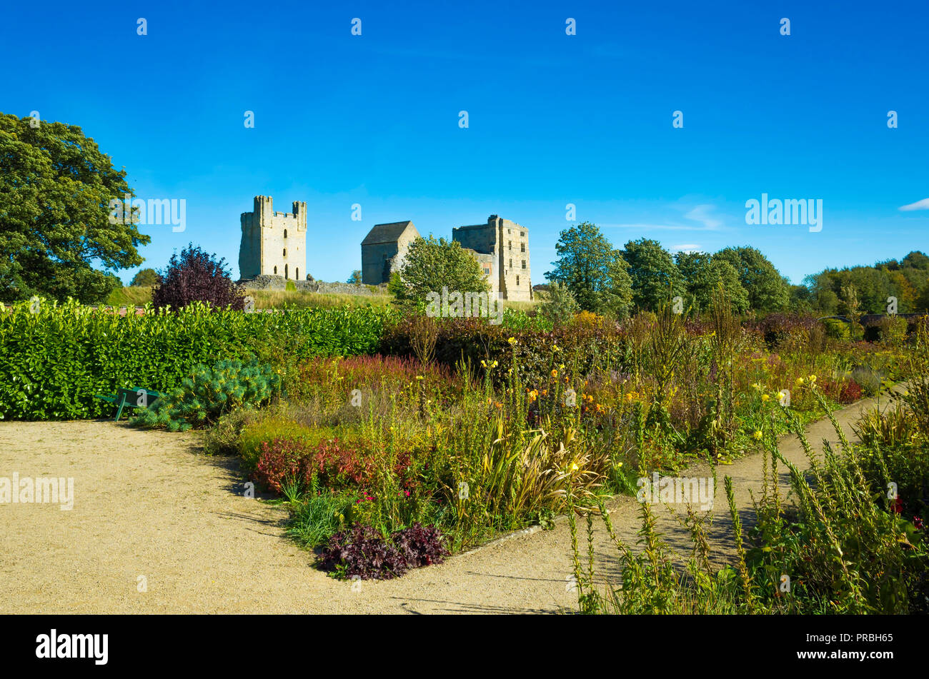 Helmsley Castle overlooking the Helmsley Walled Garden with a show of autumn flowers Stock Photo