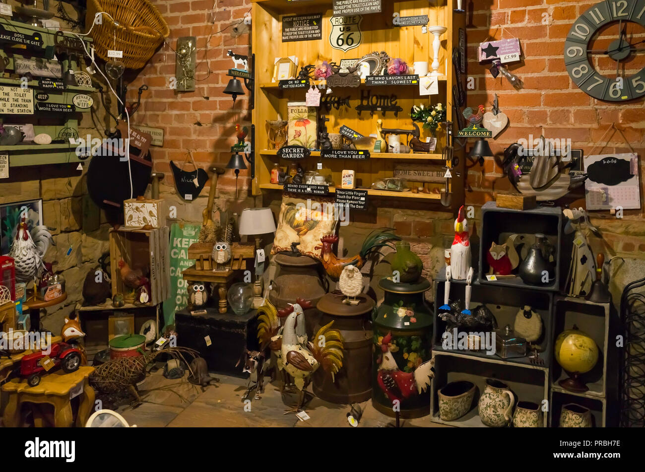 Interior of a rural garden centre and antique shop with a collection of vintage and reproduction garden tools ornaments and bric a brac Stock Photo