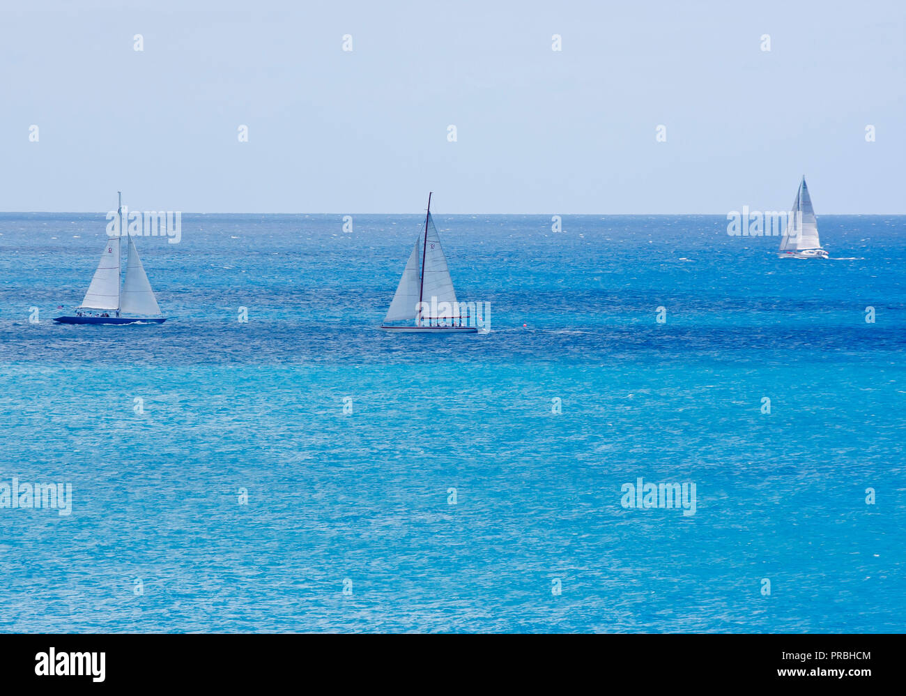 Three boats sailing across calm blue water Stock Photo - Alamy