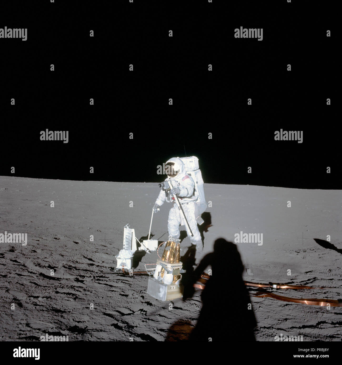 Astronaut Alan L. Bean, lunar module pilot, deploys components of the Apollo Lunar Surface Experiments Package (ALSEP) during the first Apollo 12 extravehicular activity (EVA) on the moon. The photo was made by astronaut Charles Conrad Jr., commander, using a 70mm handheld Hasselblad camera modified for lunar surface usage. Stock Photo