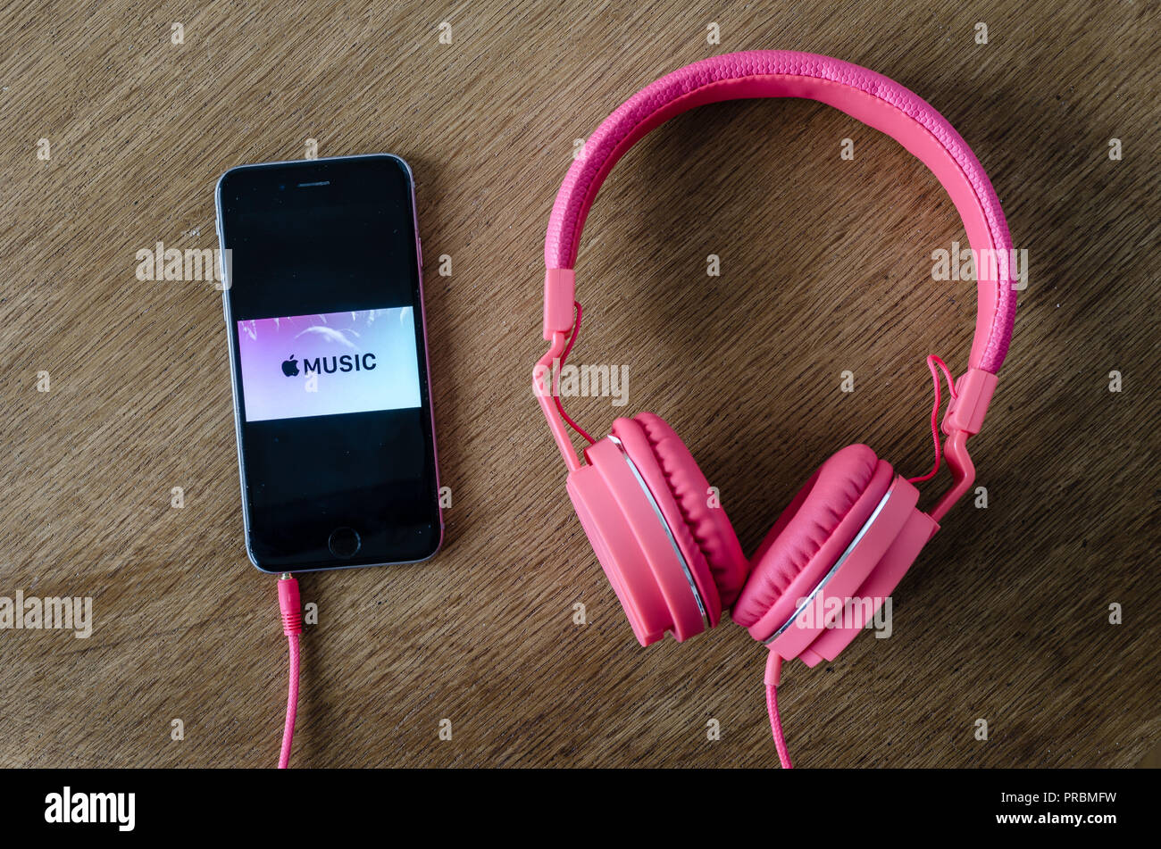 Groningen, Holland. September 29, 2018: Iphone 6 with logo of apple music and a pink headphone Stock Photo