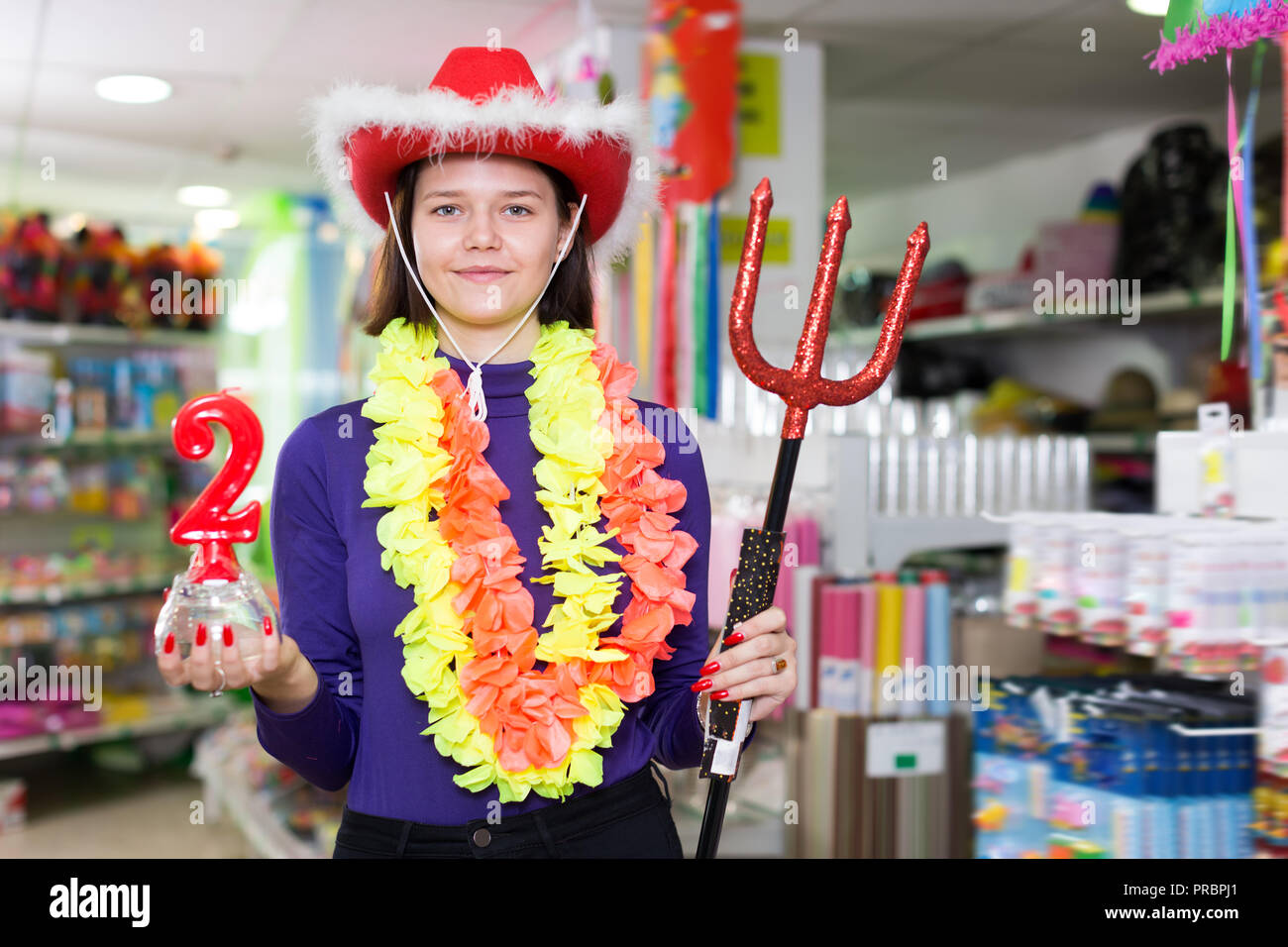 Portrait of modern comically dressed girl joking in festive accessories ...