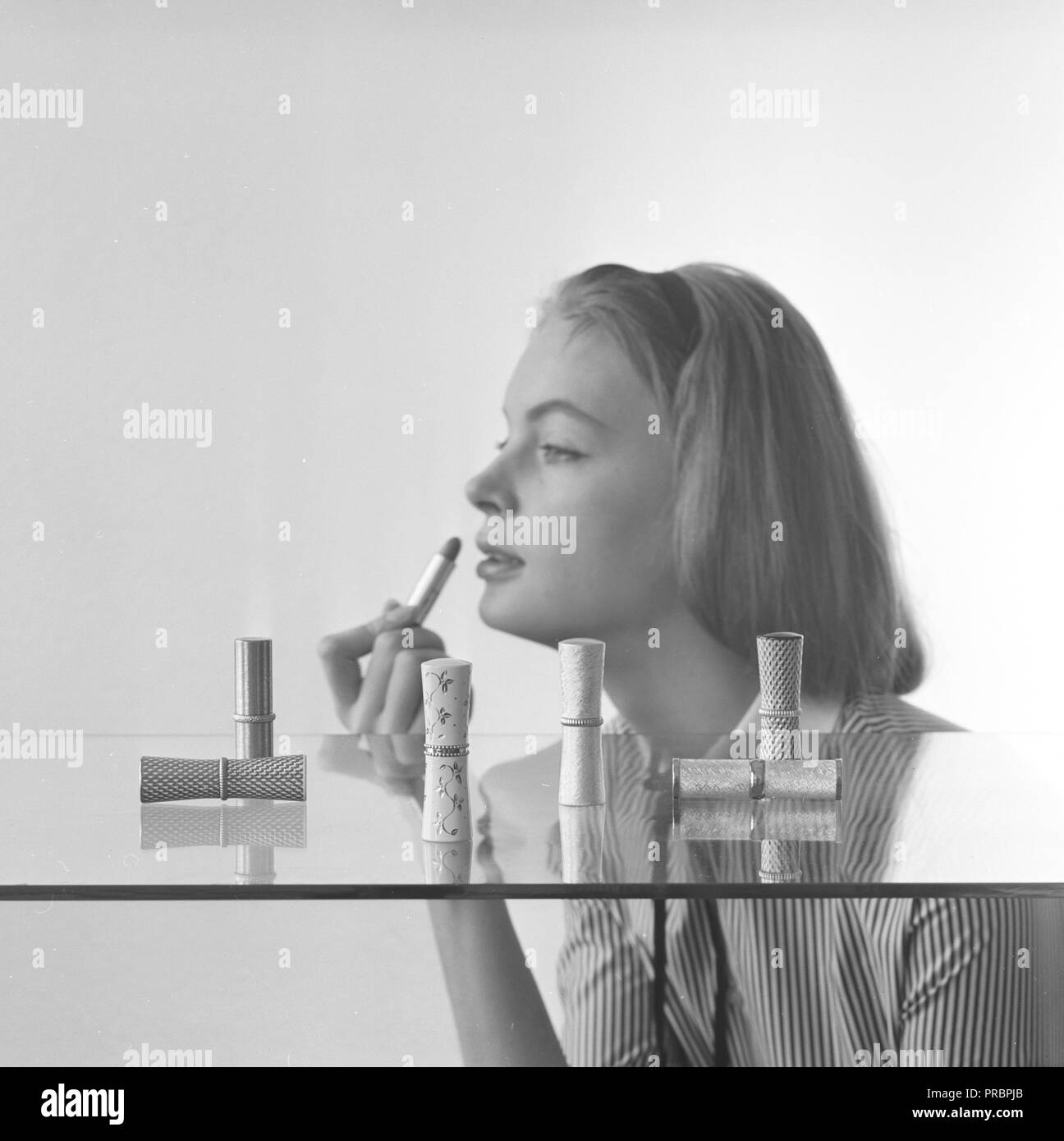 Makeup in the 1950s. A young woman applying lipstick. Sweden 1957 Stock Photo