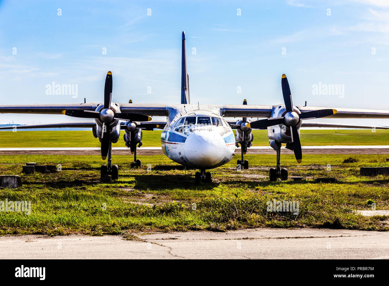 an old cargo propeller plane is standing in a parking lot near the ...
