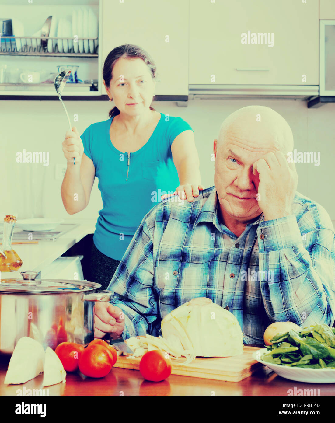 Mature married couple having quarrel at kitchen Stock Photo