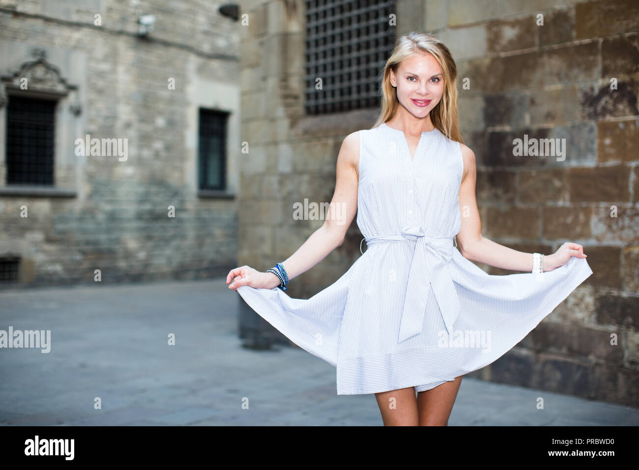 Portrait of cheerful woman holding skirt in the hand outdoors Stock Photo -  Alamy