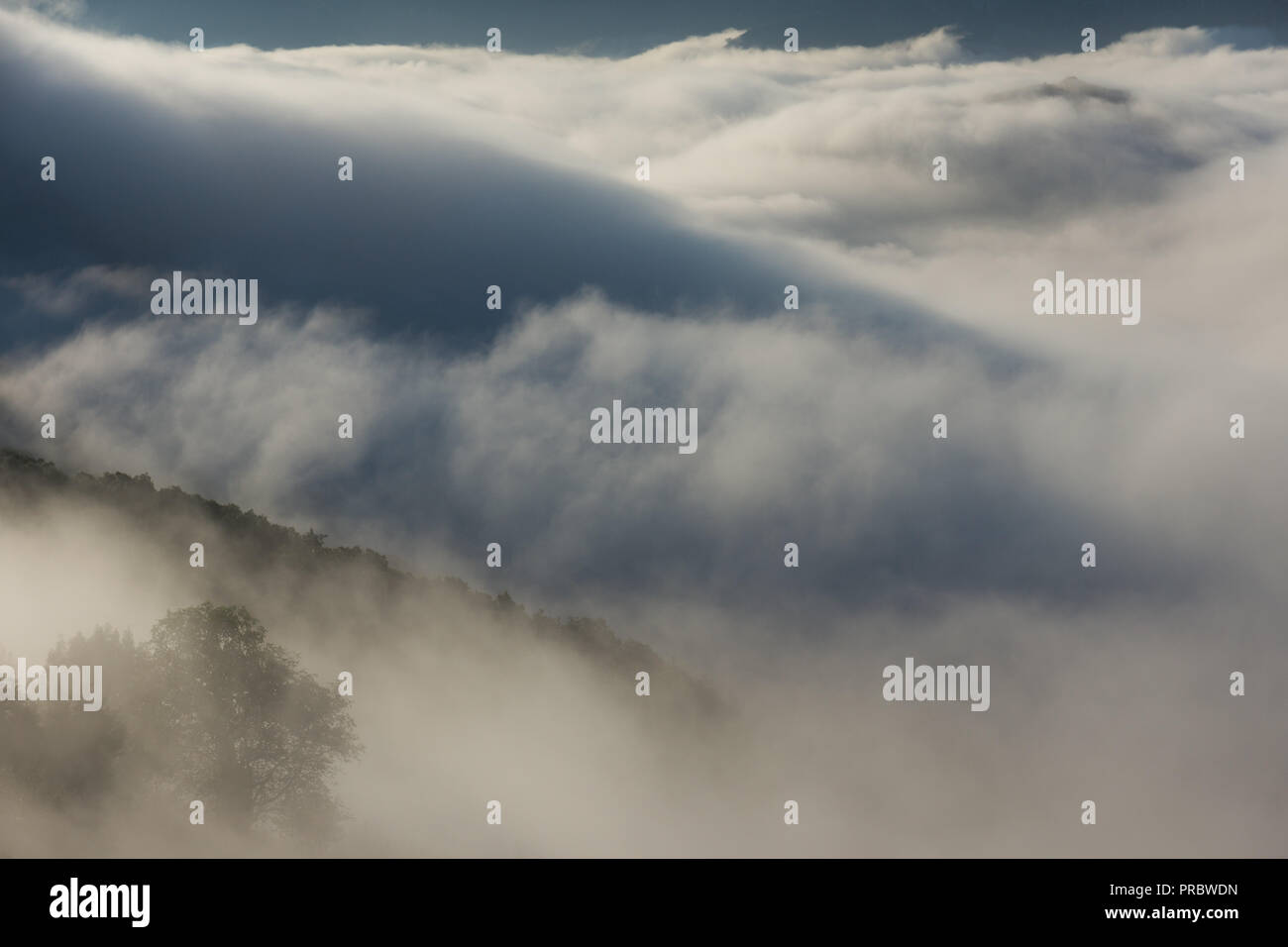 cloud inversion with shadows from mountains over a deep valley. Stock Photo