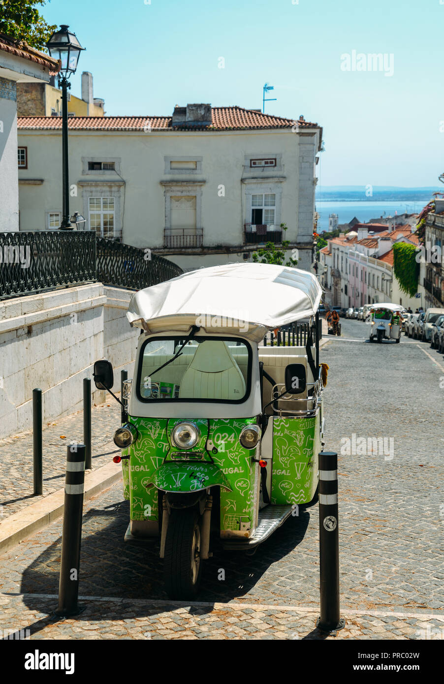 Lisbon, Portugal - Sept 23, 2018: Green Tuk-Tuk Urban Vehicle for Tourists Transportation parked at the historic Se district of Lisbon, Portugal Stock Photo