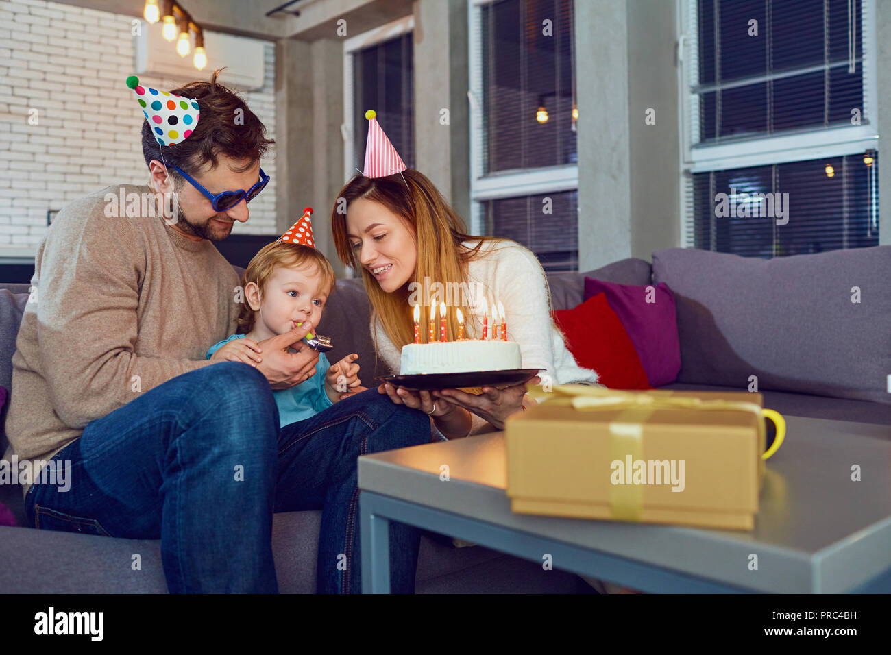 Parents with birthday cake congratulate their child. Stock Photo