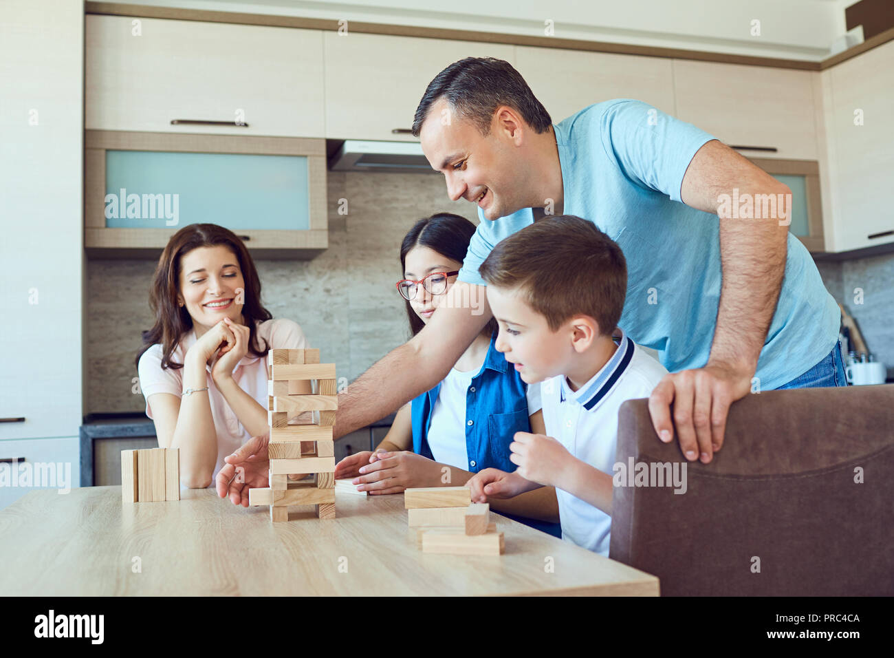A cheerful family plays board games at home.  Stock Photo