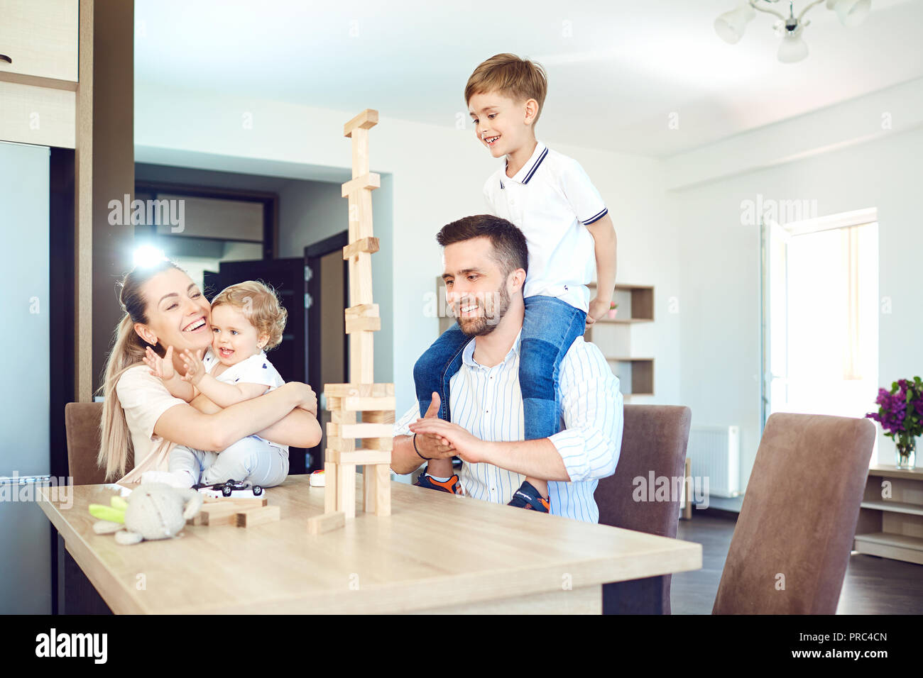 A family plays board games sitting at a table indoors. Stock Photo