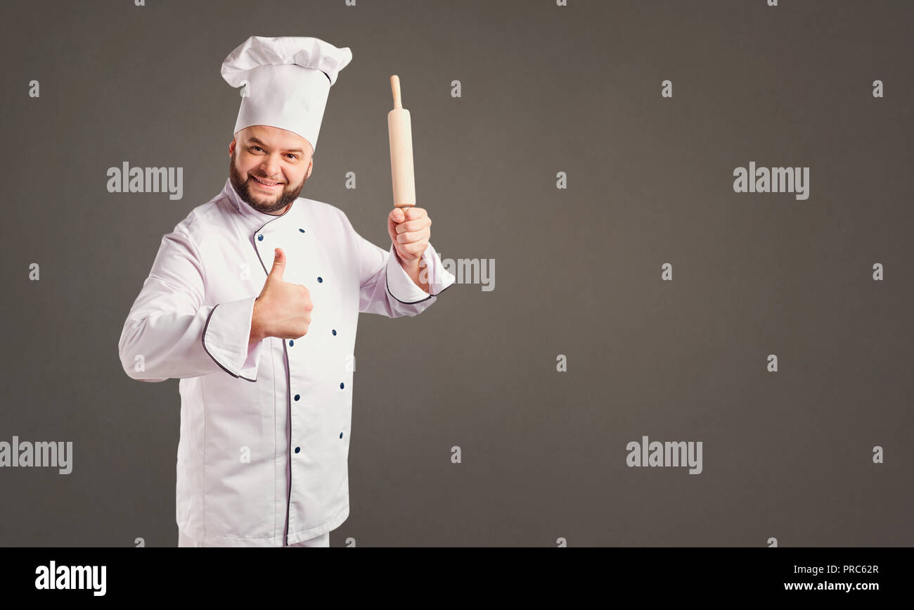 Funny cheerful chef in white uniform on a background. Stock Photo