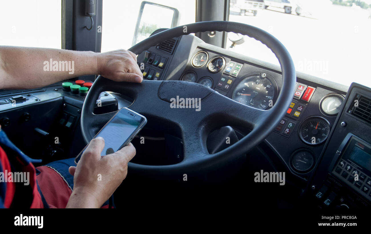 Closeup image of male driver holding smartphone while driving bus Stock ...