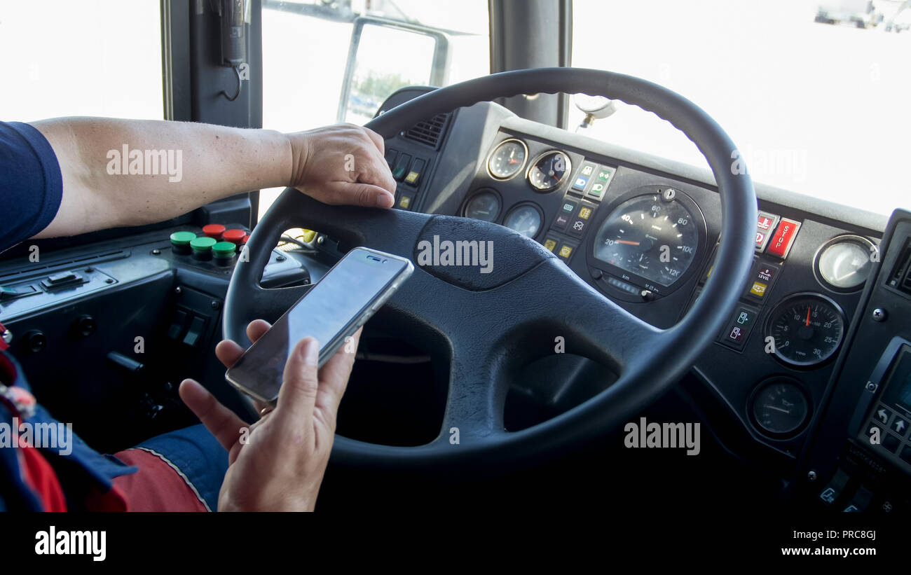 Closeup photo of irresponsible man typing phone number while driving truck. Danger in transport. Irresponsible driver Stock Photo