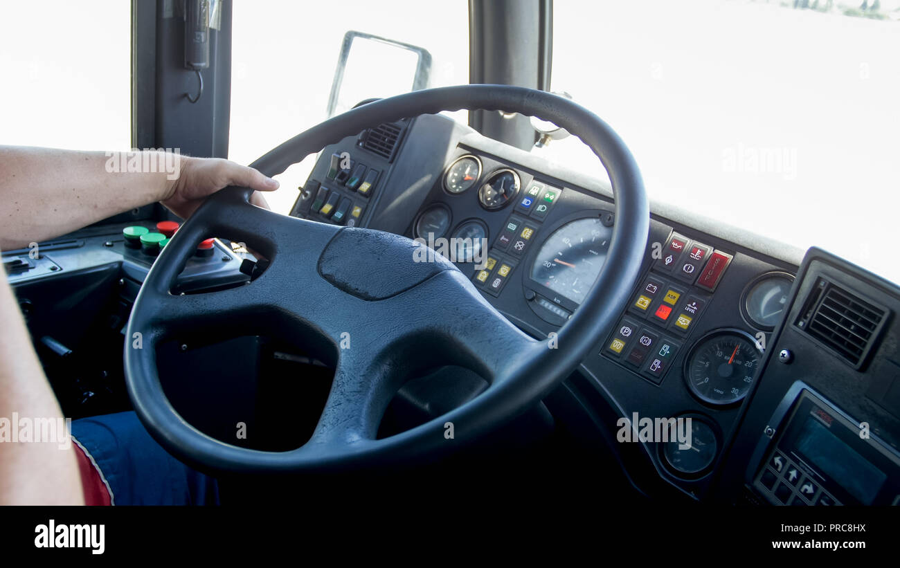 Closeup image of male hands on steering wheel while driving public bus Stock Photo