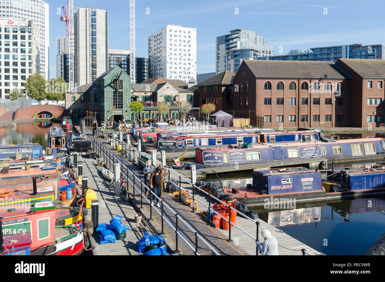 Colourful narrow boats moored in gas street basin at the heart of Birmingham's canal network with the Canal House pub in the background Stock Photo