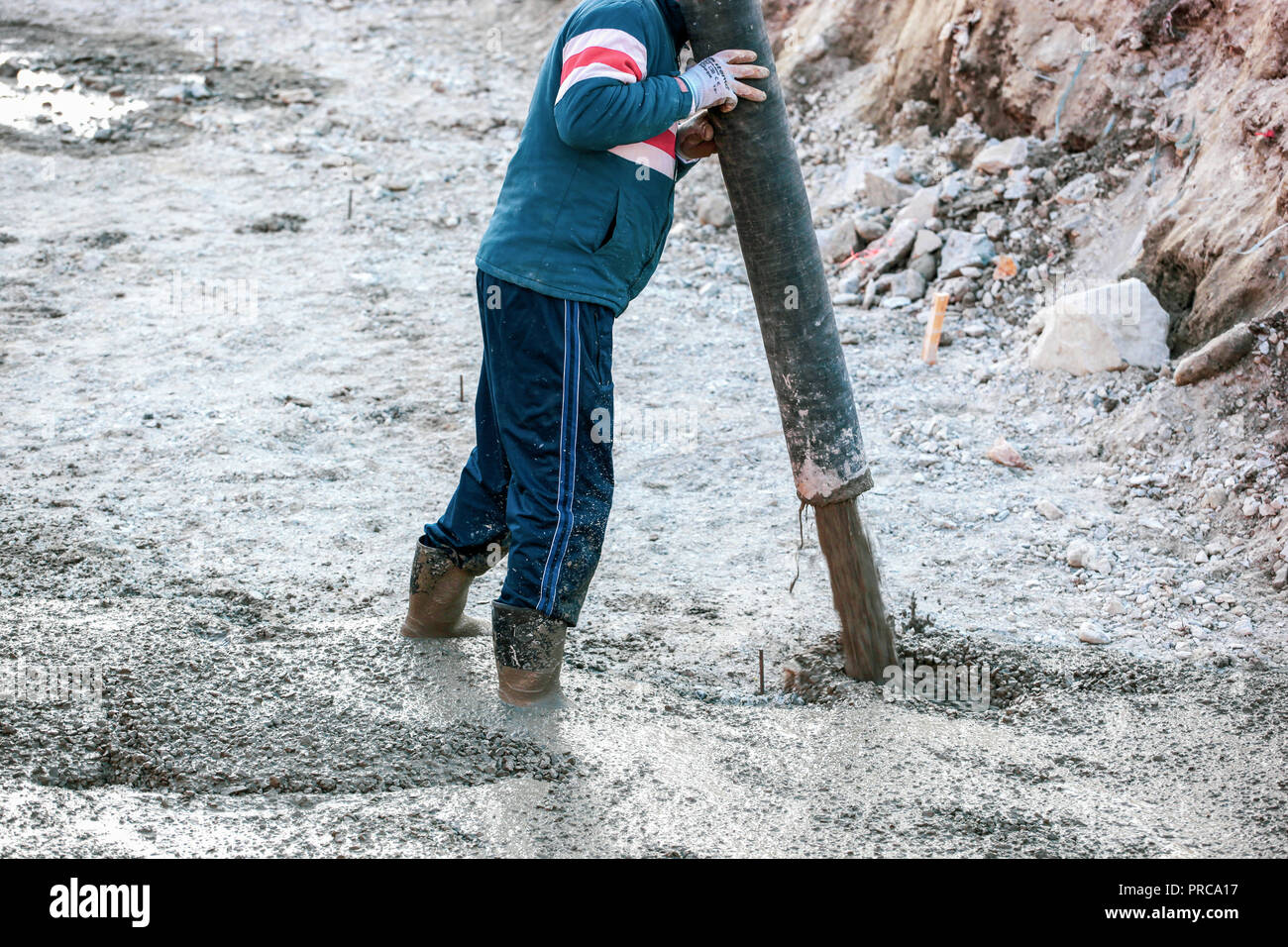Construction worker pouring cement or concrete with pump tube Stock