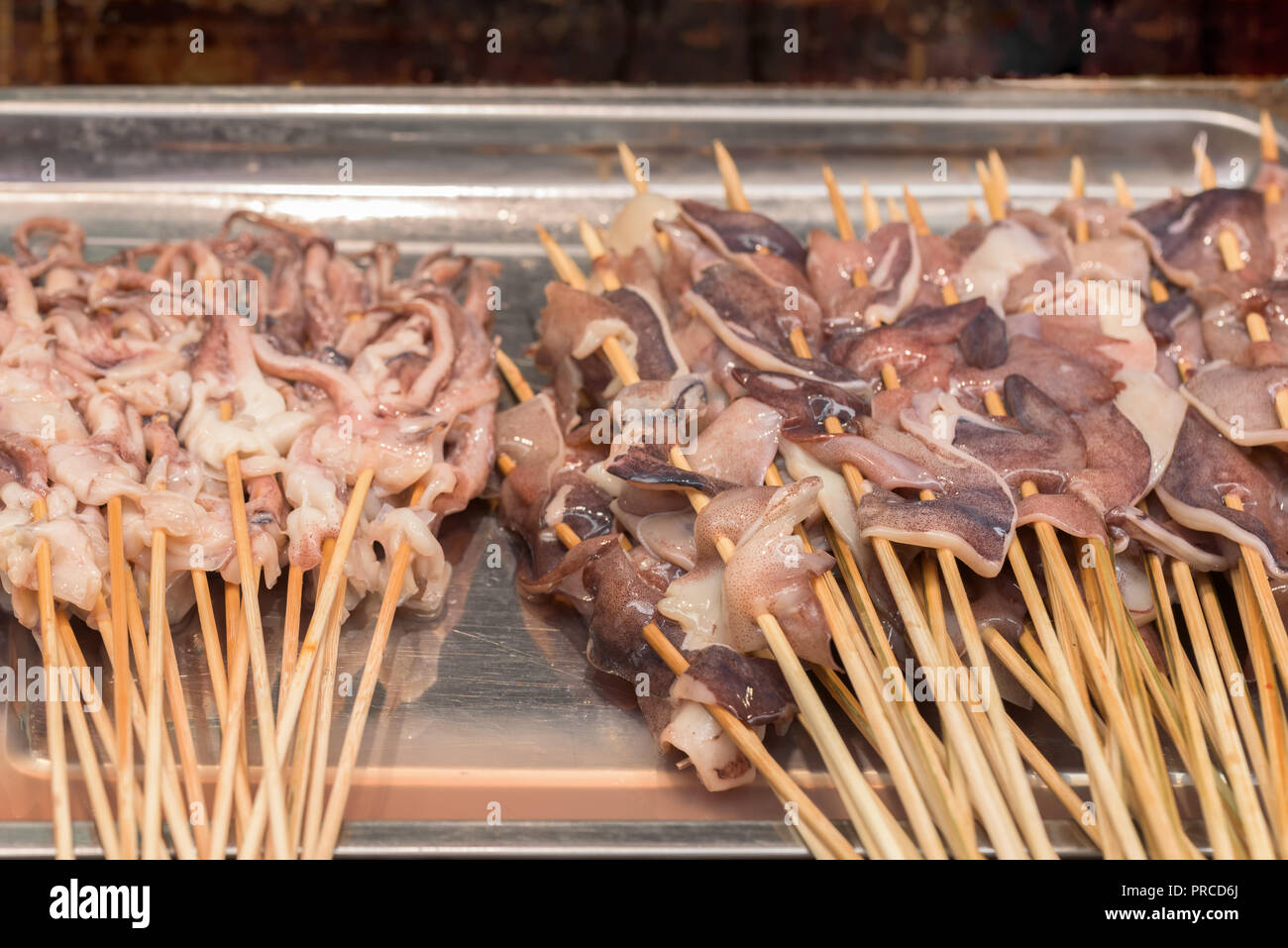 Street food asia. Squid on a stick Stock Photo - Alamy