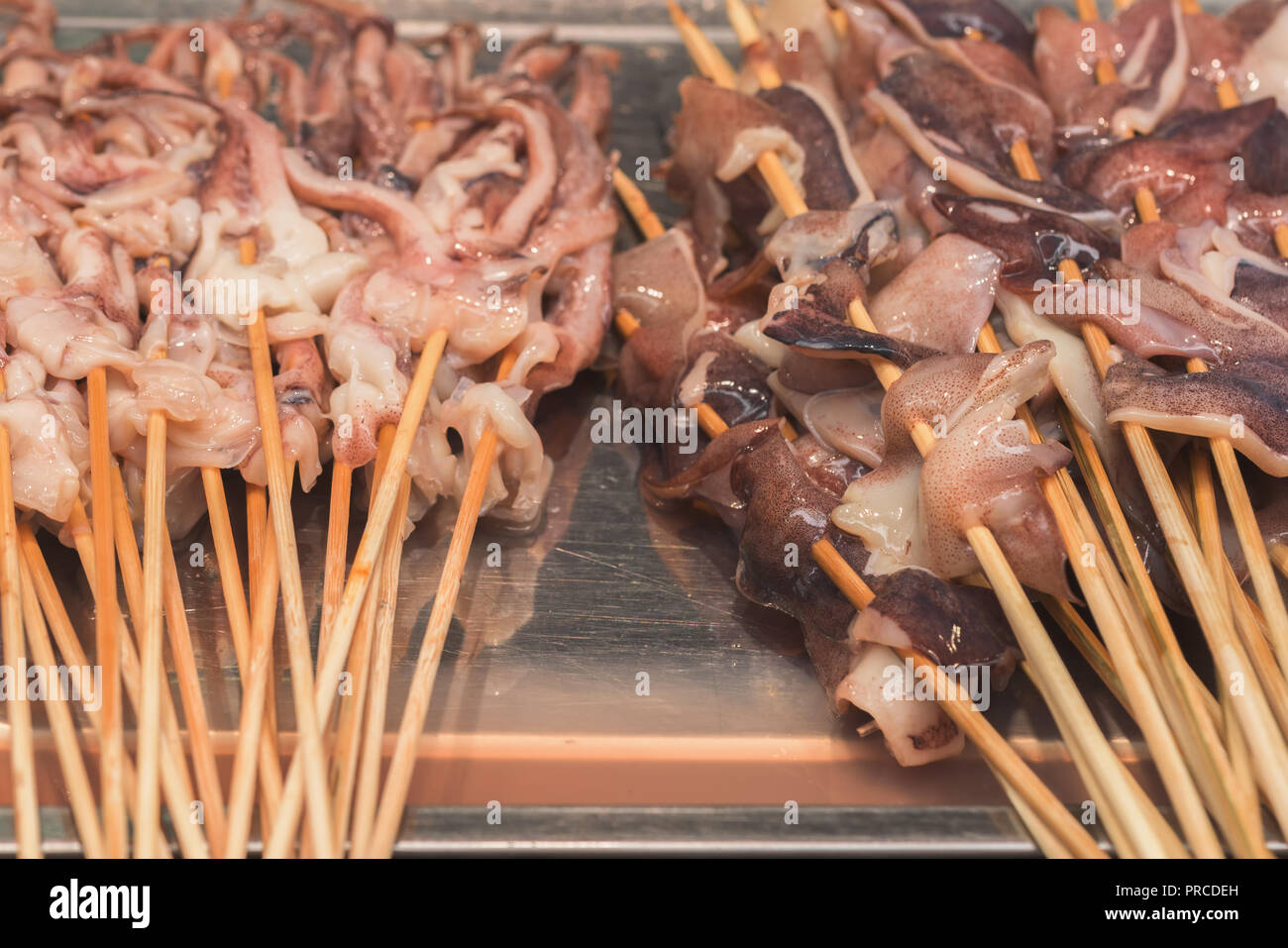 Street food asia. Squid on a stick Stock Photo - Alamy