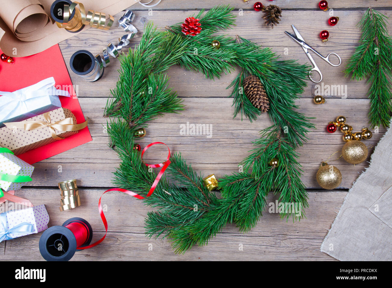 Christmas wreath on a wooden table in a workroom. Top view Stock Photo