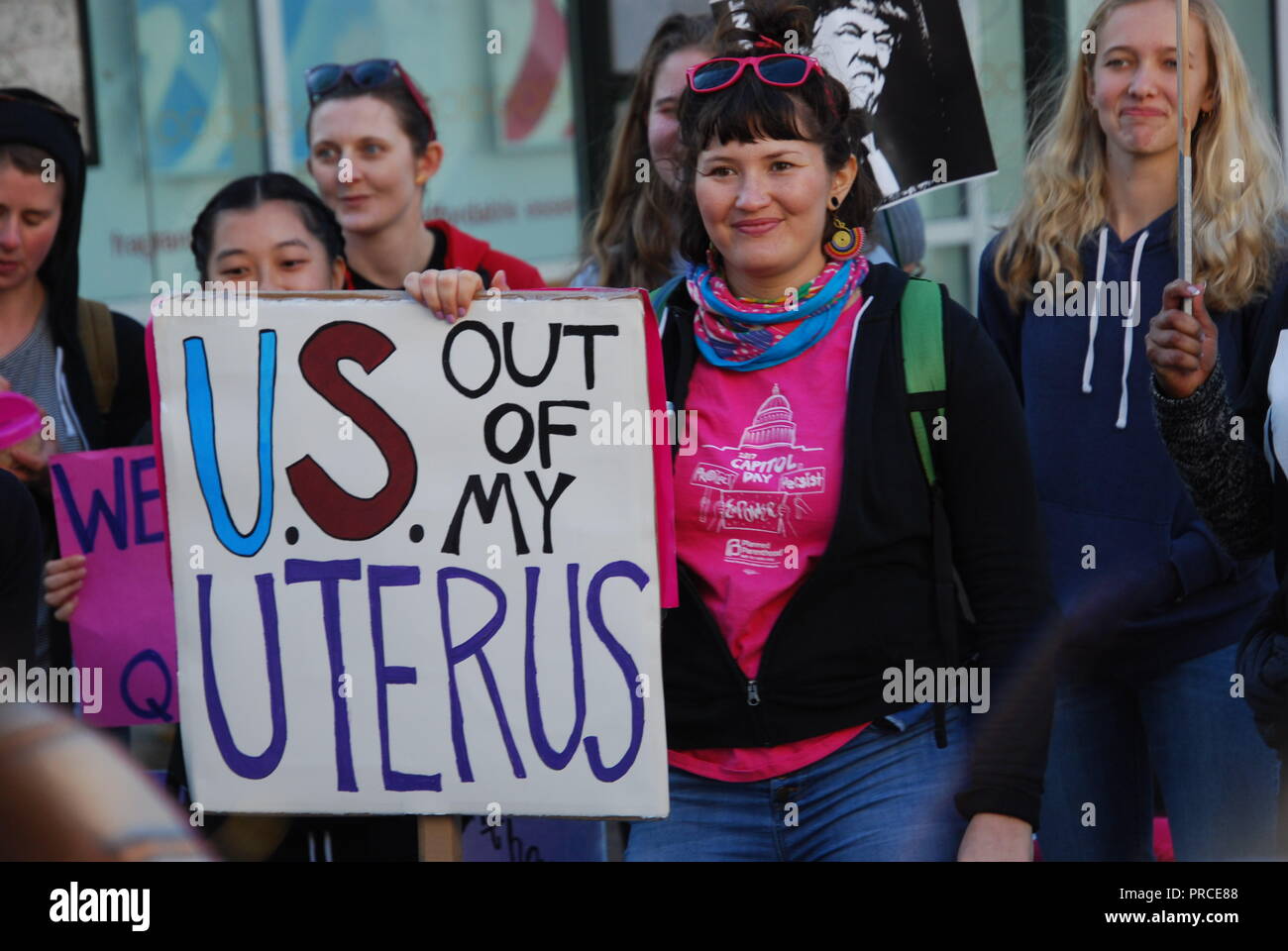 A woman stands with a sign that says 'U.S. out of my uterus' during the Women's March in downtown Oakland on Jan. 20, 2018. Stock Photo