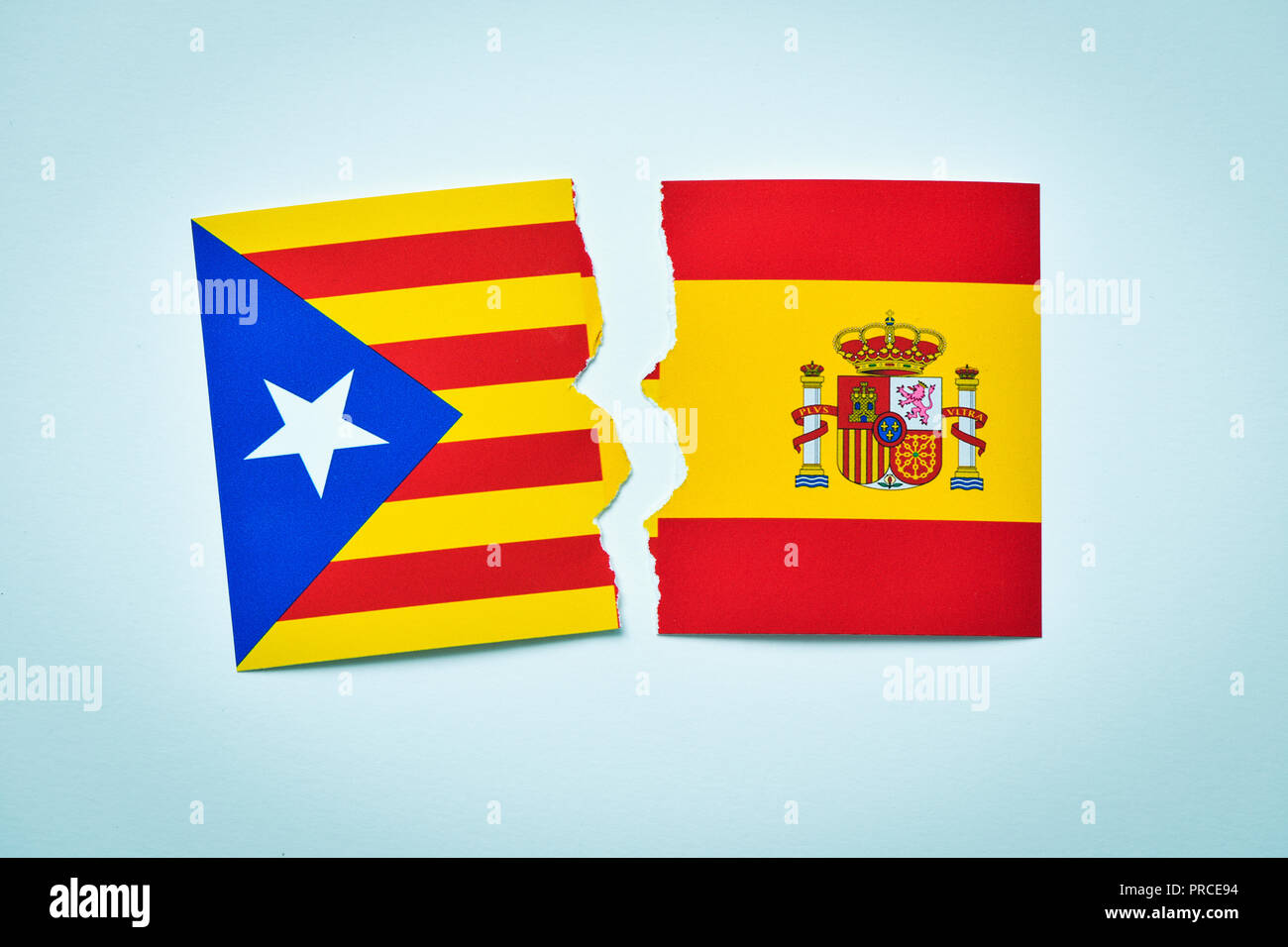 the Estelada, the Catalan pro-independence flag, and the flag of Spain, broken on an off-white background Stock Photo