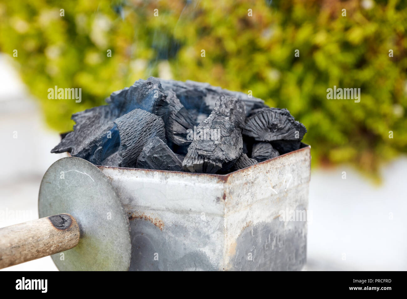 Smoking charcoal chimney starter bucket for barbecue in a backyard