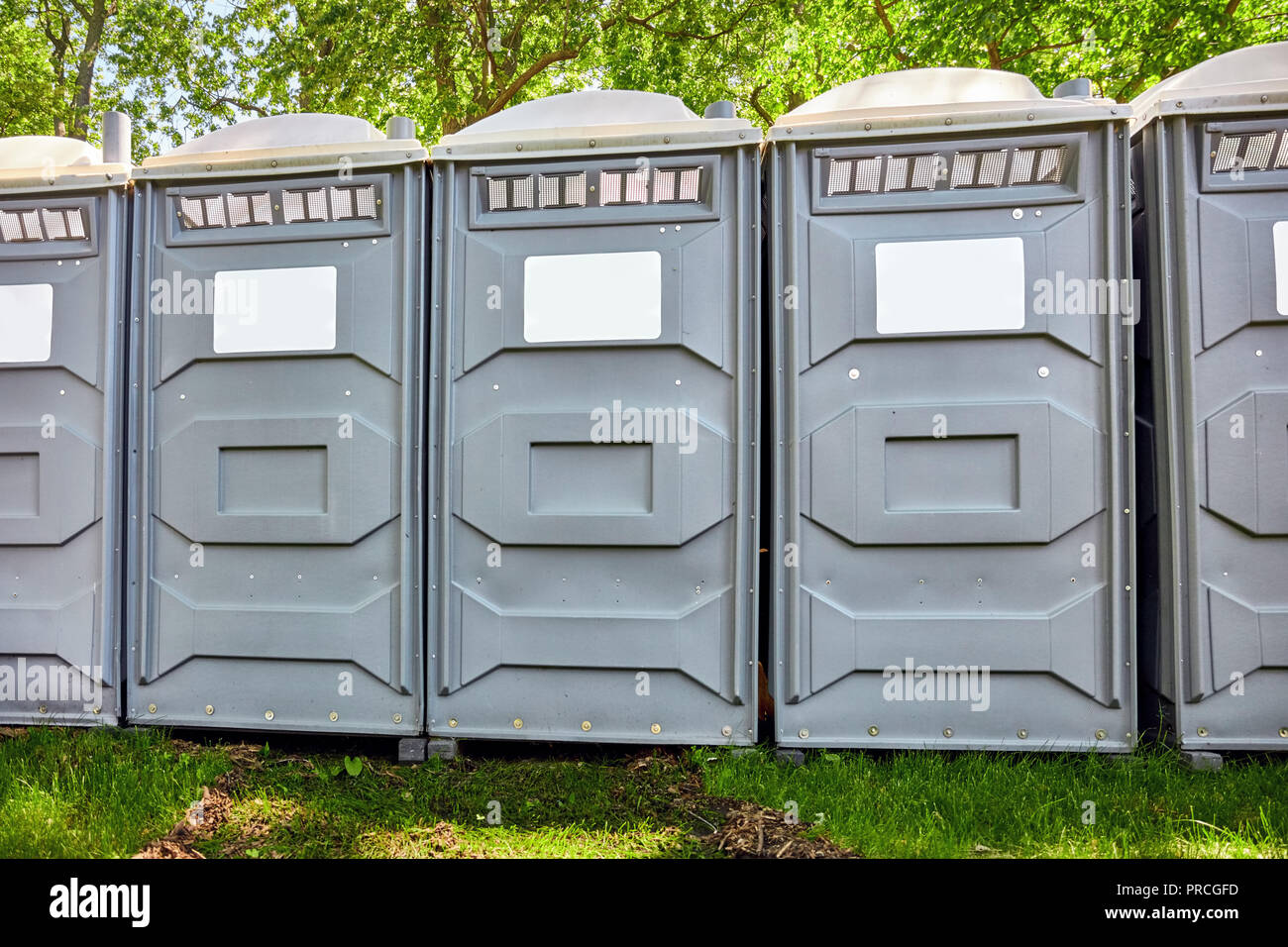 Rows of fiberglass reinforced polymer mobile toilet cabins in a park Stock Photo