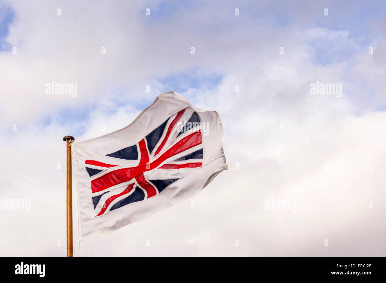 British flag on the cloudy blue sky. A flag on the wind Stock Photo - Alamy