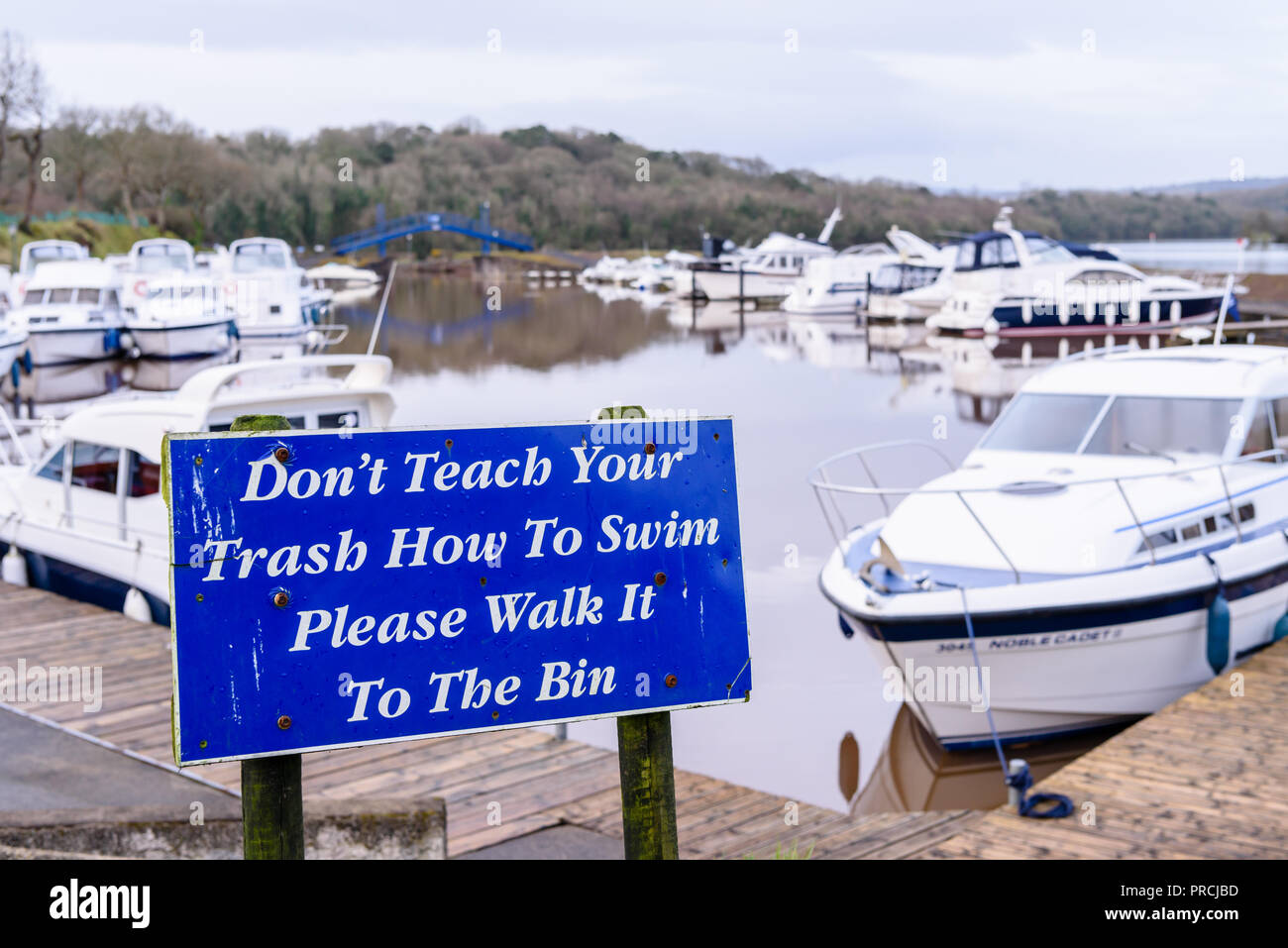 Sign saying 'Don't teach your trash how to swim.  Please walk it to the bin.' Stock Photo