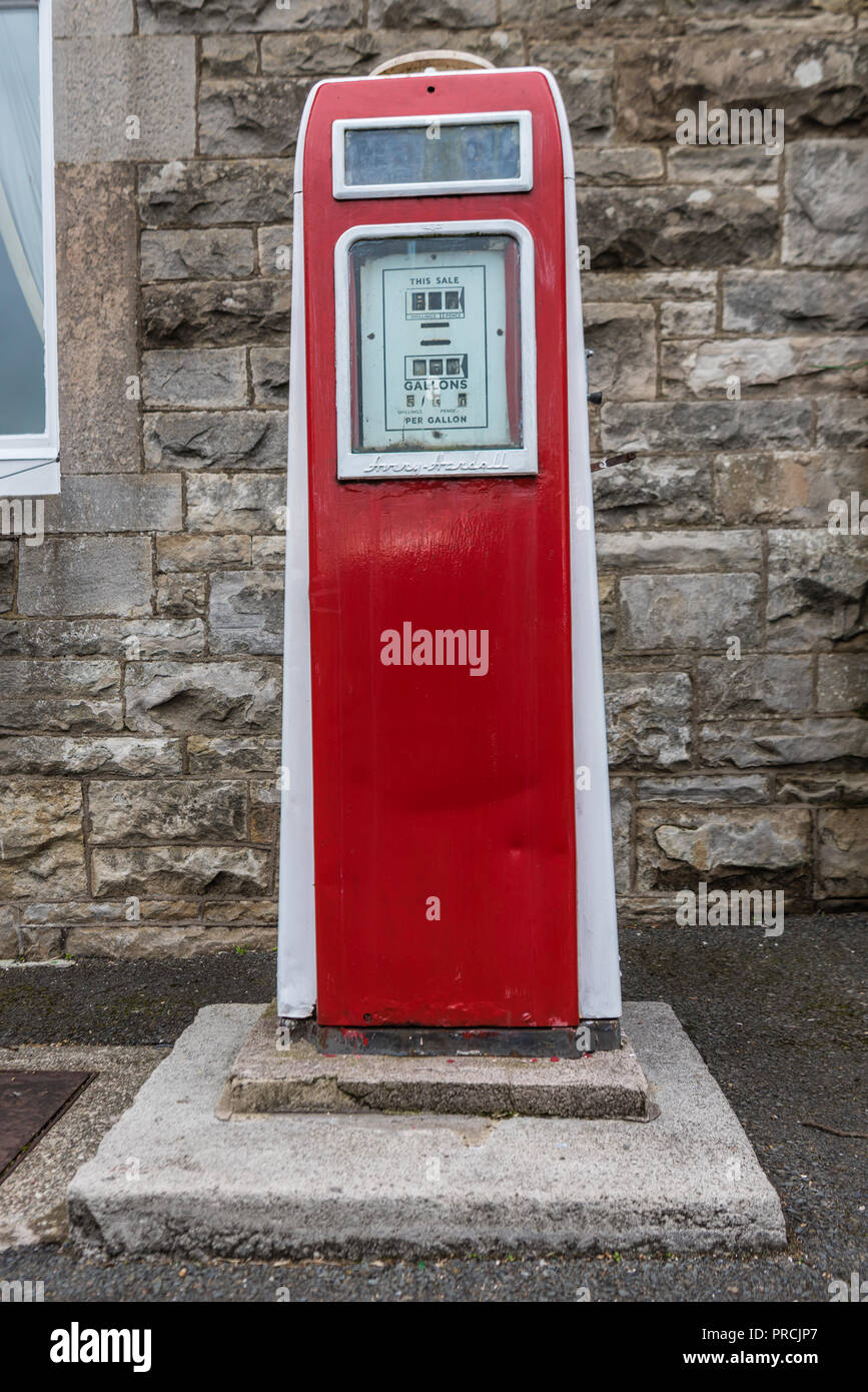 Old fashioned red petrol pump on the street in an Irish village. Stock Photo