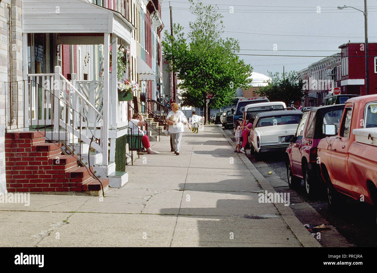 1998 - woman walking down sidewalk in urban setting Stock Photo