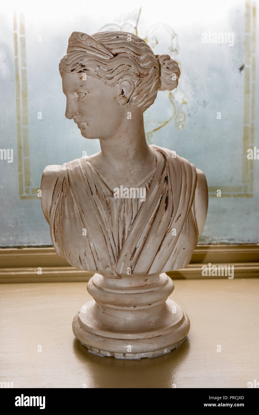 Italian marble bust the goddess Tyche by Umberto Frilli, with her head turned and wearing her distinctive tiara on the window sill of a stately hou Stock Photo