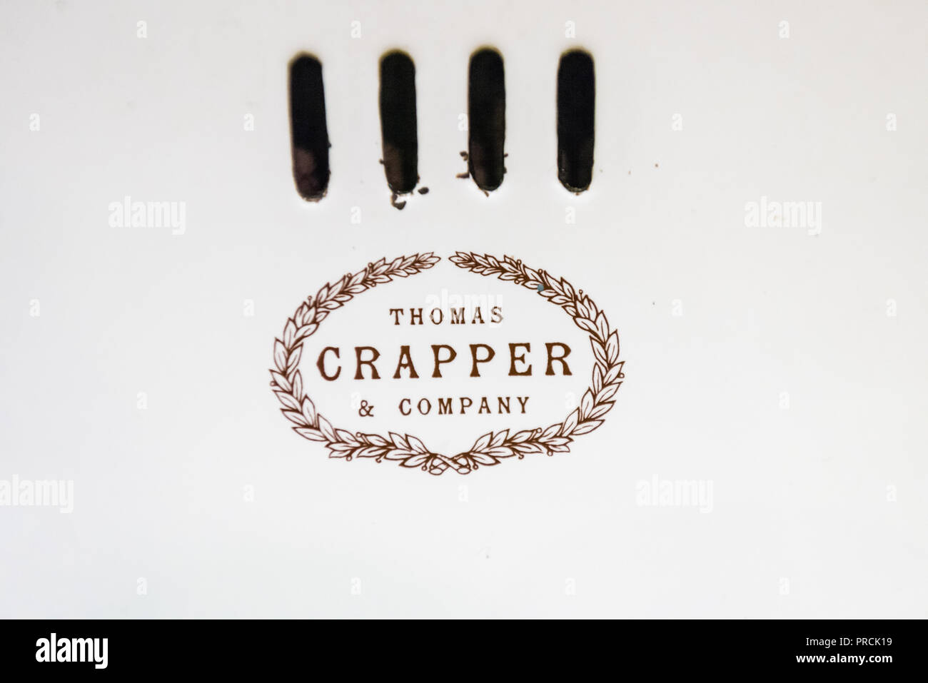 Logo on an old fashioned bathroom sink and taps made by Thomas Crapper and Company Stock Photo