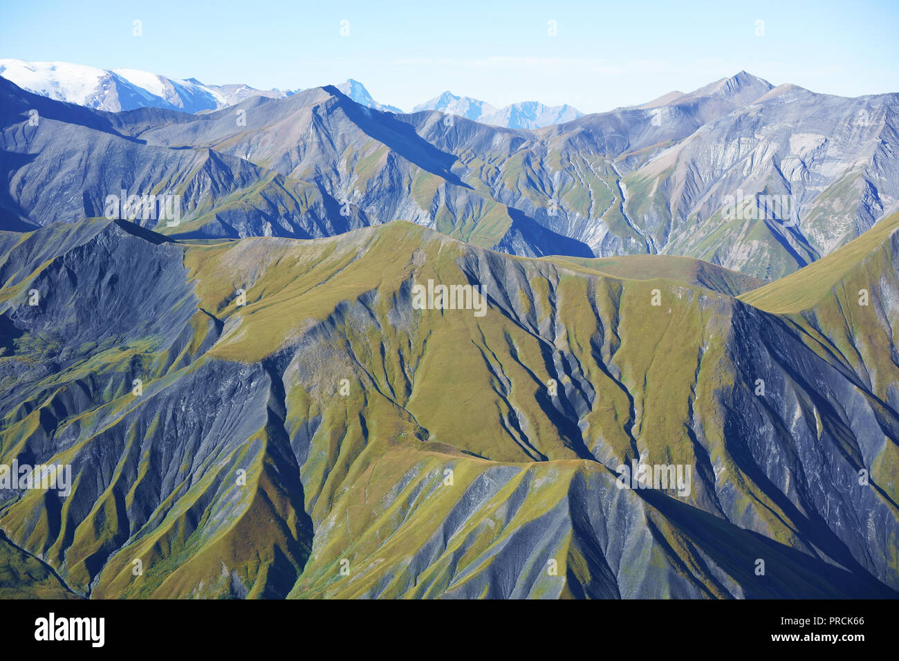 AERIAL VIEW. Landscape of grassy slopes and dark ravines above the treeline. Saint-Jean-d'Arves, Savoie, Auvergne-Rhône-Alpes, France. Stock Photo